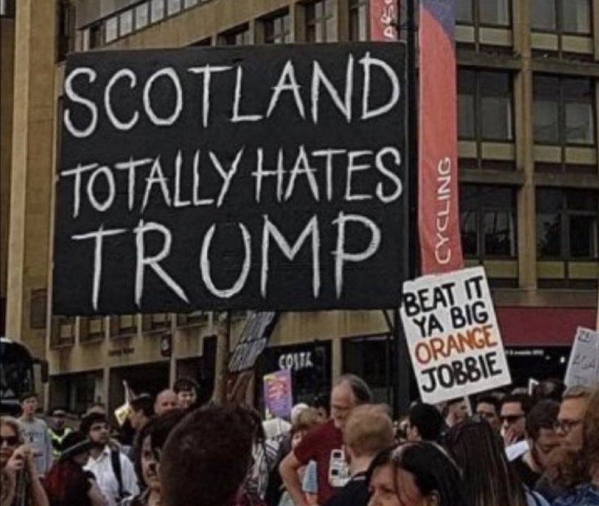 Protest in Scotland. 2 signs: 'SCOTLAND TOTALLY HATES TRUMP' and ' BEAT IT YOU BIG ORANGE JOBBIE'