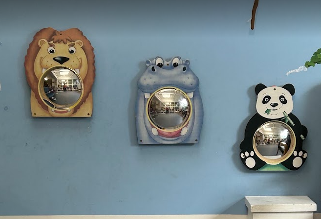 3 convex mirrors in animal frames (lion, hippo and Panda) on a mid blue wall