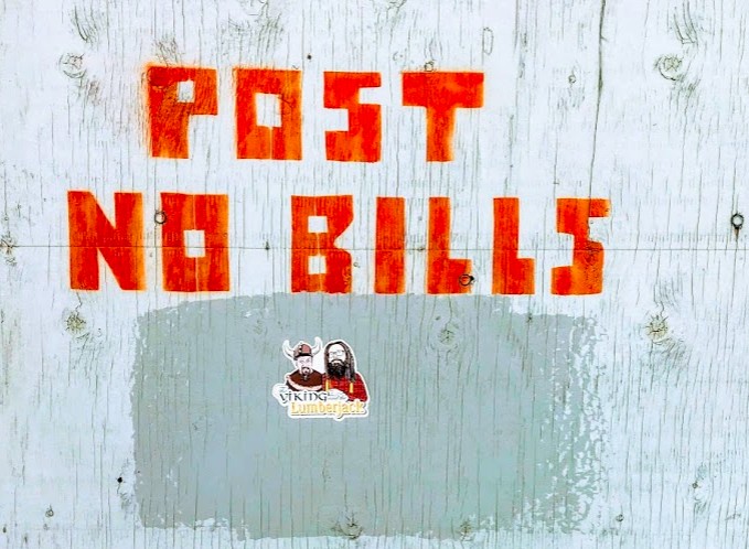 V&L sticker below a stensilled sign "POST NO BILLS" on a construction site in Toronto circa 2019